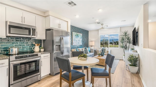 7415 Fig Grove St, Riverside, CA 92507 - kitchen featuring appliances with stainless steel finishes, light wood finished floors, white cabinets, decorative backsplash, and recessed lighting