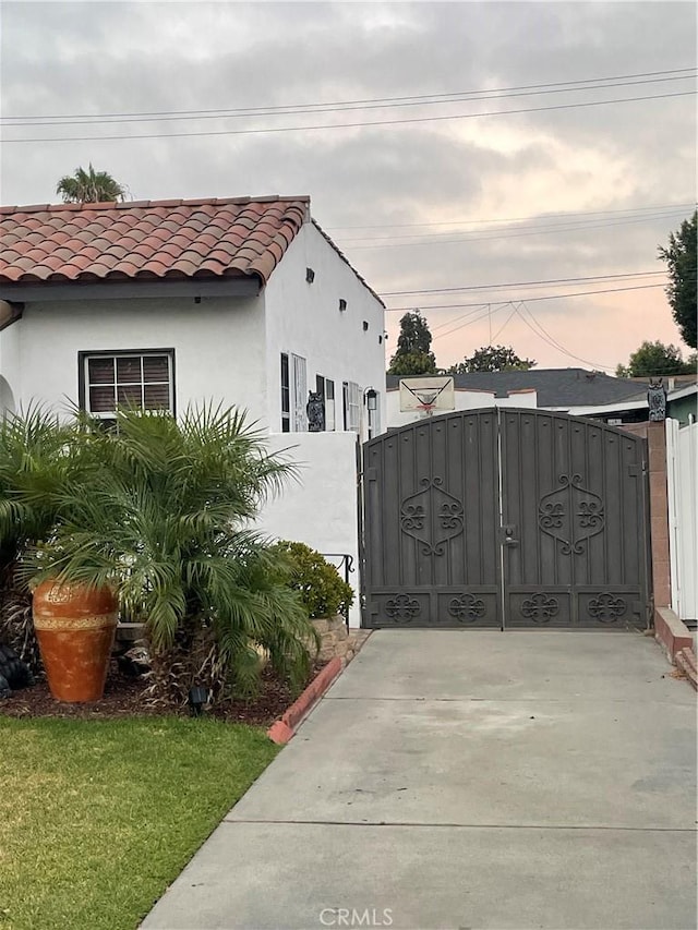 10430 San Jose Ave, South Gate, CA 90280 - view of side of property with a gate, a tiled roof, and stucco siding