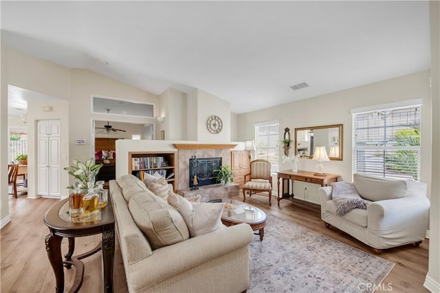 40633 Corte Albara, Murrieta, CA 92562 - living room featuring lofted ceiling, light wood finished floors, a fireplace, and a ceiling fan