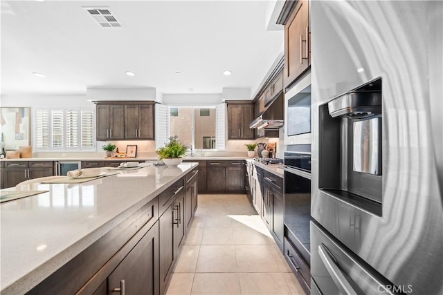 536 Cultivate, Irvine, CA 92618 - kitchen with light tile patterned floors, dark brown cabinets, stainless steel appliances, recessed lighting, and under cabinet range hood