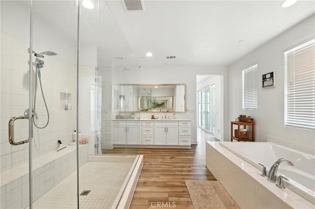 3969 Eliopulos Ranch Dr, Palmdale, CA 93551 - bathroom featuring vanity, a bath, a stall shower, wood finished floors, and recessed lighting