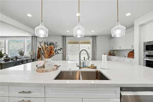 3969 Eliopulos Ranch Dr, Palmdale, CA 93551 - kitchen featuring appliances with stainless steel finishes, recessed lighting, healthy amount of natural light, white cabinets, and light stone counters