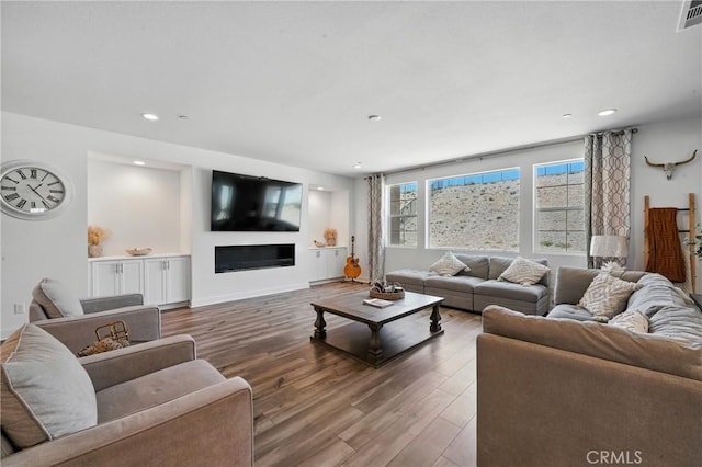 3969 Eliopulos Ranch Dr, Palmdale, CA 93551 - living area featuring wood finished floors, recessed lighting, and a glass covered fireplace