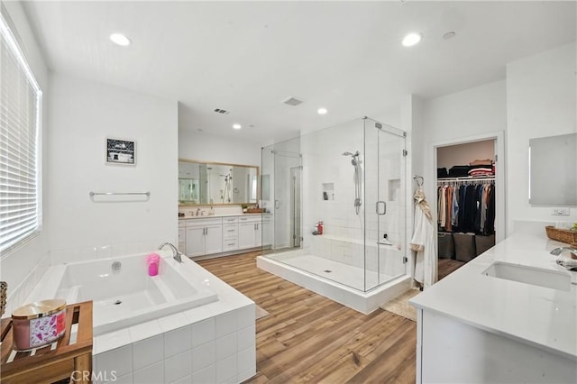 3969 Eliopulos Ranch Dr, Palmdale, CA 93551 - bathroom featuring vanity, a stall shower, a garden tub, wood finished floors, and recessed lighting