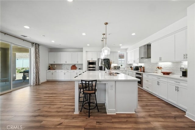 3969 Eliopulos Ranch Dr, Palmdale, CA 93551 - kitchen featuring wall chimney exhaust hood, backsplash, a kitchen bar, a kitchen island, and white cabinetry