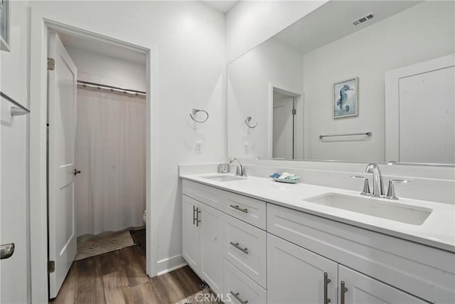 3969 Eliopulos Ranch Dr, Palmdale, CA 93551 - full bathroom with double vanity, wood finished floors, and a shower with curtain