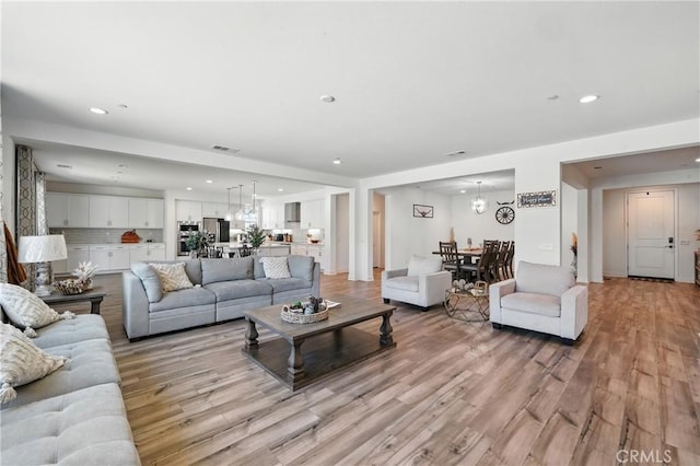 3969 Eliopulos Ranch Dr, Palmdale, CA 93551 - living area with light wood-style floors, recessed lighting, and a chandelier