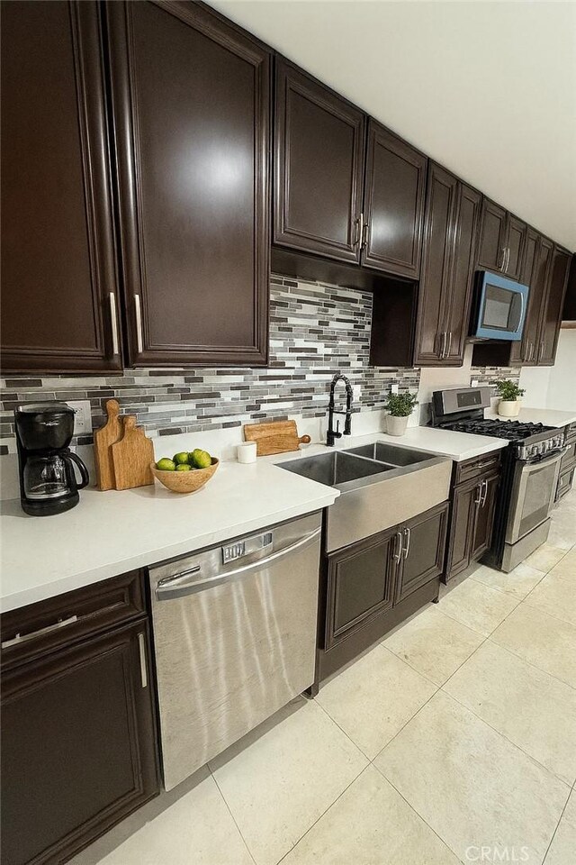 4215 Portola Ave, Los Angeles, CA 90032 - kitchen with appliances with stainless steel finishes, decorative backsplash, light tile patterned floors, light countertops, and dark brown cabinets