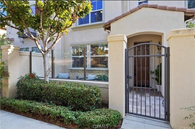 94 New Season, Irvine, CA 92602 - doorway to property with a gate, stucco siding, and a tile roof