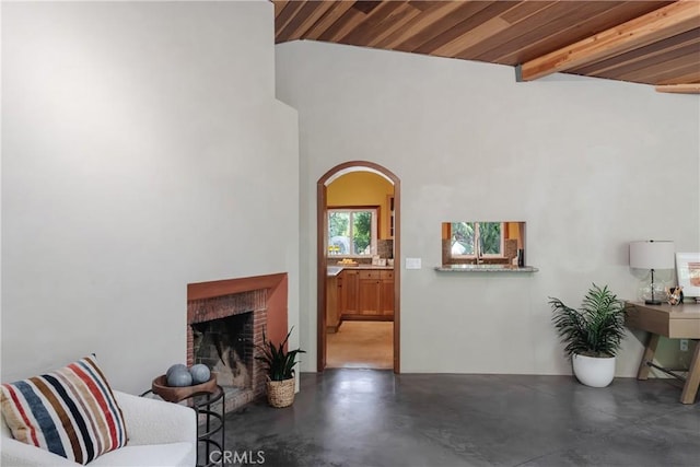 2 Chuckwagon Rd, Rolling Hills, CA 90274 - living area with finished concrete flooring, arched walkways, a fireplace, and a wood ceiling with exposed beams