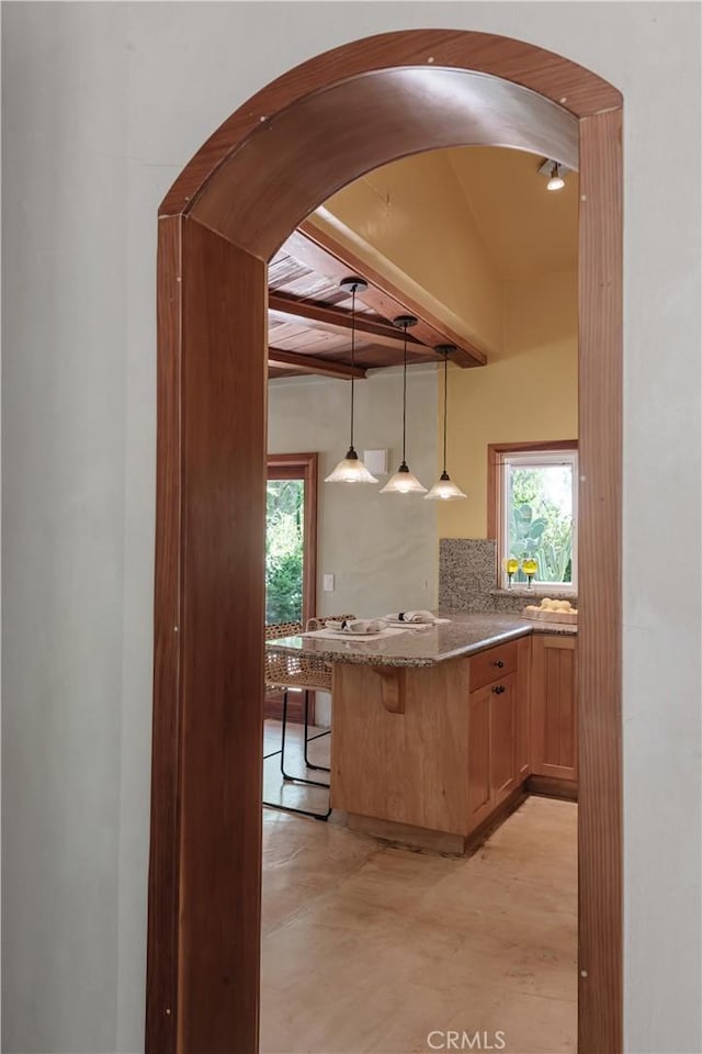 2 Chuckwagon Rd, Rolling Hills, CA 90274 - kitchen featuring beam ceiling, plenty of natural light, stone countertops, arched walkways, and finished concrete floors