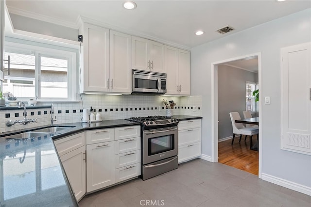 14348 Emelita St, Sherman Oaks, CA 91401 - kitchen with stainless steel appliances, backsplash, white cabinets, recessed lighting, and crown molding