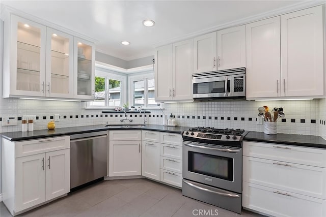 14348 Emelita St, Sherman Oaks, CA 91401 - kitchen with appliances with stainless steel finishes, dark countertops, white cabinetry, light tile patterned flooring, and crown molding
