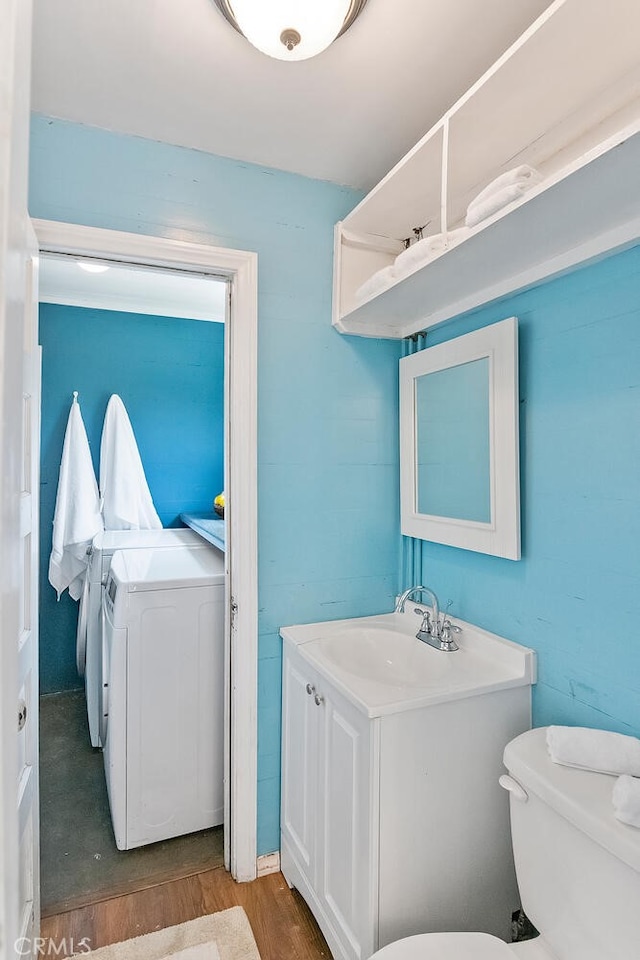 14348 Emelita St, Sherman Oaks, CA 91401 - bathroom featuring separate washer and dryer, vanity, and wood finished floors