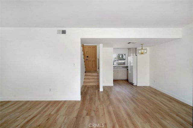 18931 Kittridge St Unit 73, Reseda, CA 91335 - unfurnished living room featuring light wood finished floors and a chandelier