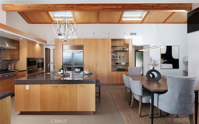 10551 Hillsboro Rd, North Tustin, CA 92705 - kitchen with appliances with stainless steel finishes, a kitchen island with sink, exhaust hood, dark countertops, and a chandelier