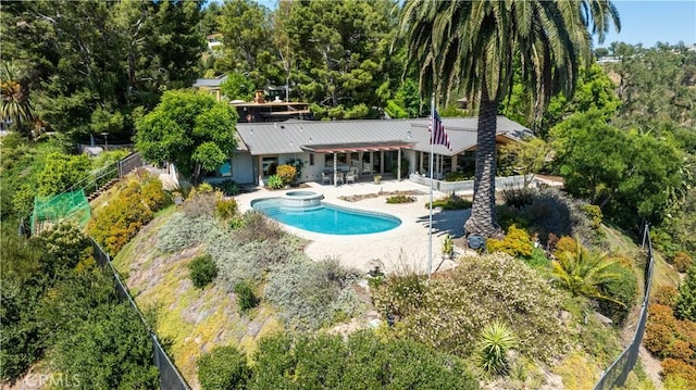 10551 Hillsboro Rd, North Tustin, CA 92705 - back of house featuring a pool with connected hot tub, a patio, a fenced backyard, and a metal roof