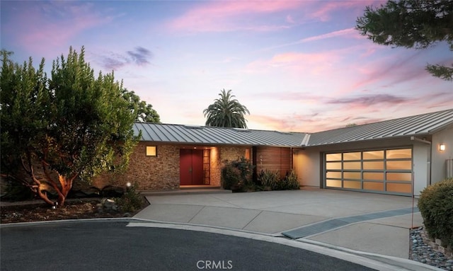 10551 Hillsboro Rd, North Tustin, CA 92705 - view of front of home featuring a standing seam roof, concrete driveway, an attached garage, and a metal roof