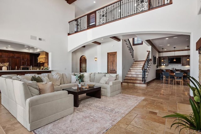 8183 Doug Hill, San Diego, CA 92127 - living area featuring a high ceiling, stone tile flooring, stairs, arched walkways, and recessed lighting