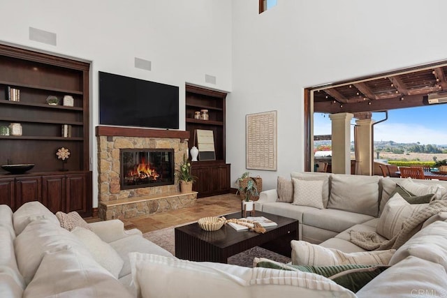 8183 Doug Hill, San Diego, CA 92127 - living area with healthy amount of natural light, a stone fireplace, built in features, and a towering ceiling