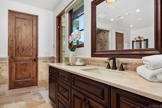 8183 Doug Hill, San Diego, CA 92127 - bathroom featuring vanity, tile walls, stone tile flooring, recessed lighting, and a wainscoted wall
