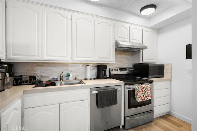 11025 Kittridge St Unit 128, North Hollywood, CA 91606 - kitchen with stainless steel appliances, under cabinet range hood, backsplash, and white cabinetry