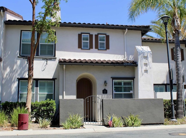 2174 Desert Hare Ct Unit 105, Chula Vista, CA 91915 - mediterranean / spanish house featuring a tiled roof, a fenced front yard, stucco siding, and a gate