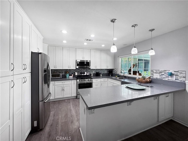 19891 Athenon Ave, Perris, CA 92570 - kitchen with appliances with stainless steel finishes, dark wood-style floors, a peninsula, tasteful backsplash, and recessed lighting