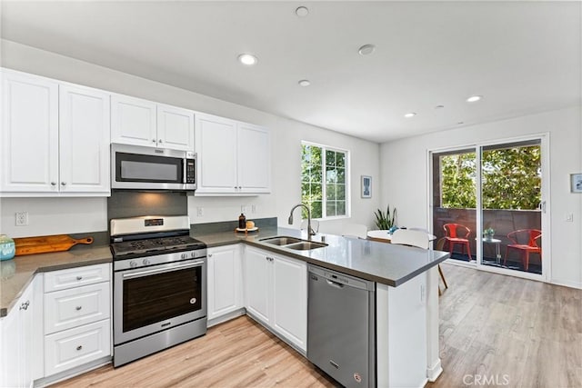 1166 Newberry Ln Unit 1, Claremont, CA 91711 - kitchen featuring stainless steel appliances, a peninsula, light wood-style flooring, white cabinetry, and recessed lighting