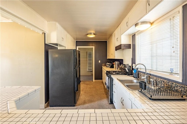 5772 Arrowhead Lake Rd, Hesperia, CA 92345 - kitchen with freestanding refrigerator, stainless steel range with gas stovetop, tile countertops, white cabinets, and carpet