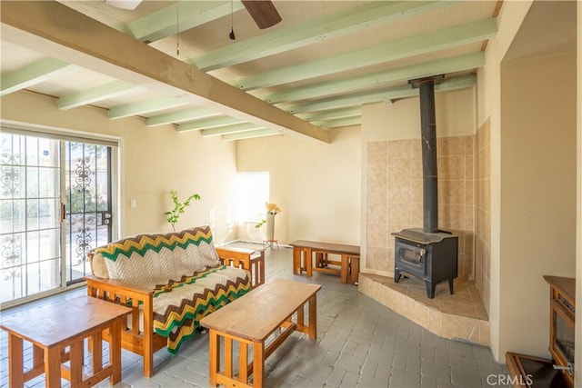 5772 Arrowhead Lake Rd, Hesperia, CA 92345 - living area featuring beamed ceiling, a wood stove, and ceiling fan