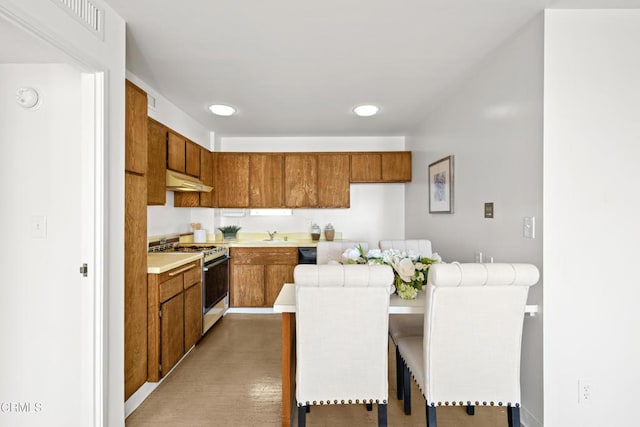 800 W 1st St Unit 1701, Los Angeles, CA 90012 - kitchen featuring white range with gas cooktop, brown cabinetry, light countertops, under cabinet range hood, and recessed lighting