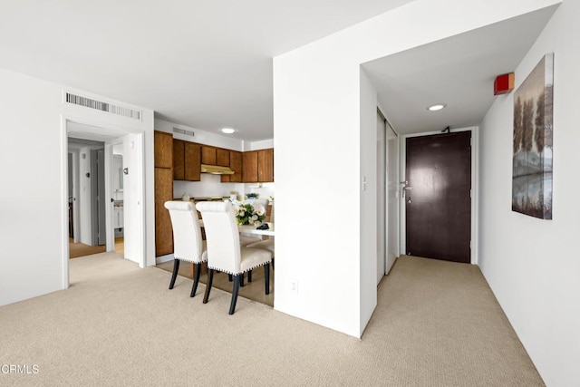 800 W 1st St Unit 1701, Los Angeles, CA 90012 - kitchen featuring light carpet, brown cabinetry, light countertops, recessed lighting, and a kitchen bar