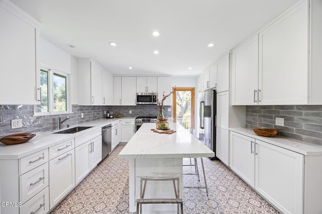 4520 Lone Pine Ln, La Canada Flintridge, CA 91011 - kitchen with stainless steel appliances, white cabinets, backsplash, recessed lighting, and a kitchen bar