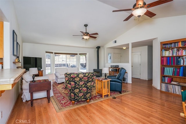 45337 Valley Oak Dr, Ahwahnee, CA 93601 - living room with a ceiling fan, a wood stove, vaulted ceiling, and light wood-style floors