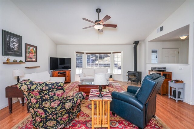 45337 Valley Oak Dr, Ahwahnee, CA 93601 - living room featuring a wood stove, vaulted ceiling, ceiling fan, and wood finished floors