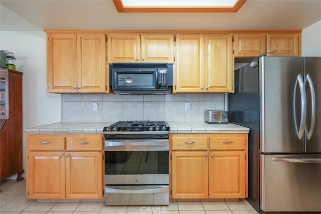 45337 Valley Oak Dr, Ahwahnee, CA 93601 - kitchen featuring stainless steel appliances, tile countertops, decorative backsplash, and light tile patterned floors