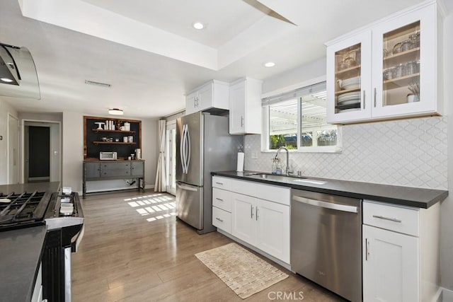 3314 Benton Ave, La Verne, CA 91750 - kitchen with stainless steel appliances, dark countertops, decorative backsplash, white cabinets, and light wood finished floors