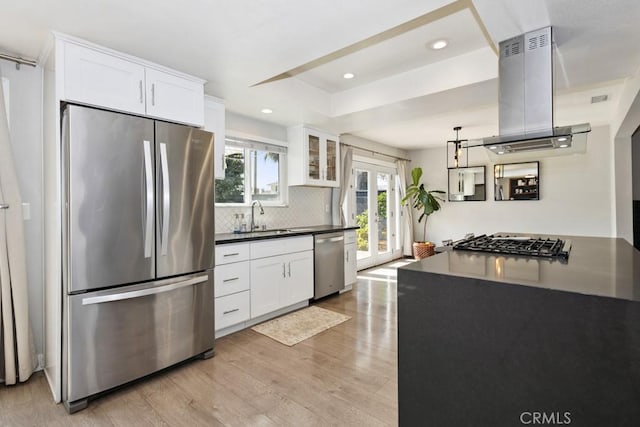3314 Benton Ave, La Verne, CA 91750 - kitchen featuring stainless steel appliances, island exhaust hood, light wood-style floors, decorative backsplash, and dark countertops