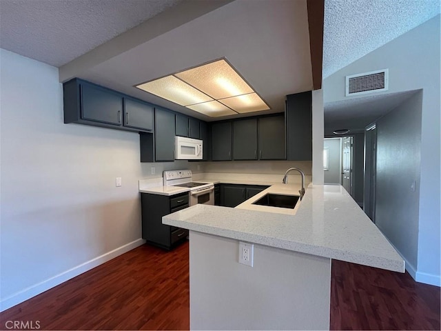 22 Country Mile Rd, Pomona, CA 91766 - kitchen with white appliances, a peninsula, dark wood-type flooring, and a textured ceiling