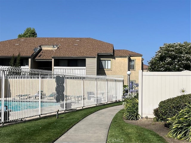 22 Country Mile Rd, Pomona, CA 91766 - back of property featuring a community pool, a shingled roof, and stucco siding
