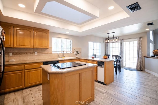 26511 Mainsail Ln, Helendale, CA 92342 - kitchen featuring a raised ceiling, black appliances, a center island, a peninsula, and light countertops