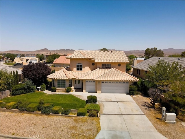 26511 Mainsail Ln, Helendale, CA 92342 - mediterranean / spanish house featuring concrete driveway, a mountain view, a front lawn, a tiled roof, and stucco siding