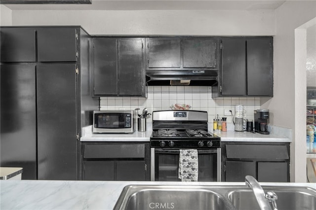 11286 Parkside Ln Unit 22, Garden Grove, CA 92843 - kitchen featuring appliances with stainless steel finishes, under cabinet range hood, decorative backsplash, light countertops, and gray cabinets