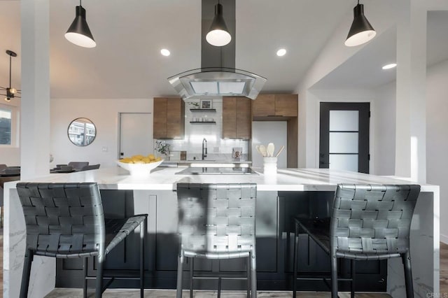 3356 Lockwood Dr, San Diego, CA 92123 - kitchen with brown cabinetry, black electric cooktop, modern cabinets, tasteful backsplash, and pendant lighting