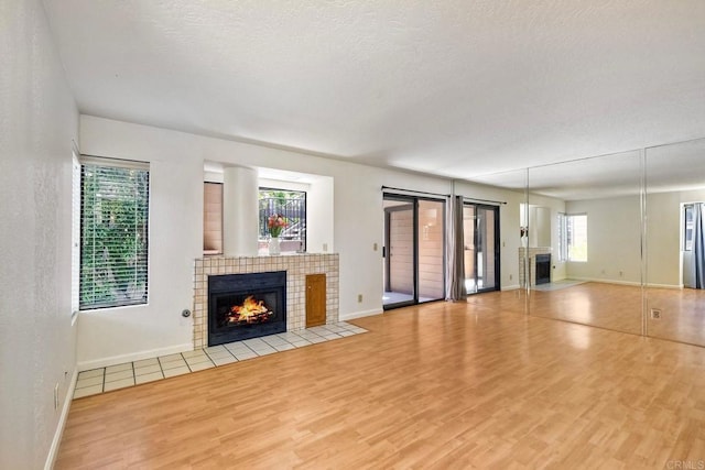 4015 Canario St Unit E, Carlsbad, CA 92008 - unfurnished living room with a fireplace, wood finished floors, and a textured ceiling