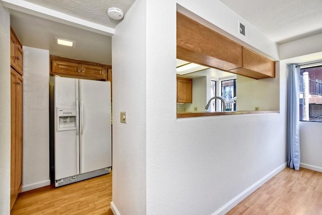 4015 Canario St Unit E, Carlsbad, CA 92008 - kitchen featuring white refrigerator with ice dispenser, light wood-style floors, and brown cabinetry