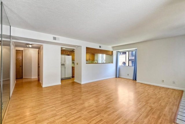 4015 Canario St Unit E, Carlsbad, CA 92008 - unfurnished living room with light wood-type flooring and a textured ceiling