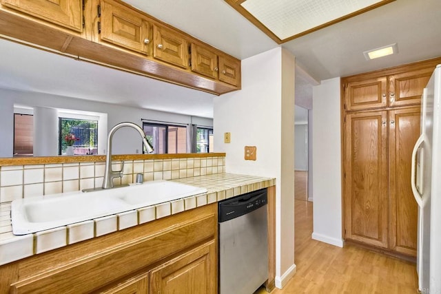 4015 Canario St Unit E, Carlsbad, CA 92008 - kitchen with stainless steel dishwasher, white fridge, light wood-type flooring, tile countertops, and brown cabinetry