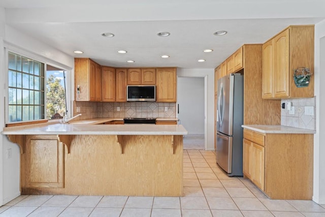 6174 Syracuse Way, San Diego, CA 92122 - kitchen with stainless steel appliances, a peninsula, light countertops, tasteful backsplash, and recessed lighting